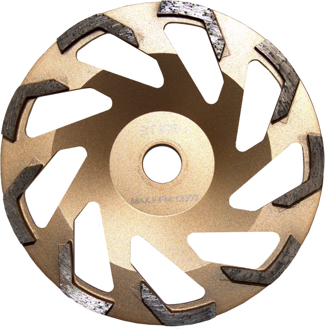 WOLFF_Dummy_75406_BT K20 gold 180mm_2025-08 Close-up photograph of a segmented diamond grinding cup wheel viewed from above. The tool has a metallic gold-painted steel body with a central arbor hole and multiple curved radial ventilation cutouts. Around the outer rim are evenly spaced, raised diamond segments with a textured, dark grey appearance and visible wear marks, arranged in a staggered spiral pattern to aid material removal. The wheel surface shows a matte metallic finish and faint stamped markings near the center indicating manufacturer codes and maximum RPM; the design and segment shape suggest it is intended for grinding concrete, stone or similar hard materials with an angle grinder or concrete grinder.